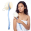 Woman holding a long-handled blue bath brush featuring a dual-sided loofah sponge and soft bristle head
