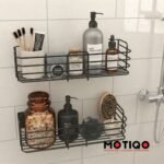 Two black wire shower caddies mounted on a tiled bathroom wall, holding various toiletries and personal care items