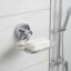Chrome wall-mounted soap dish holding a bar of white soap on a tiled shower wall